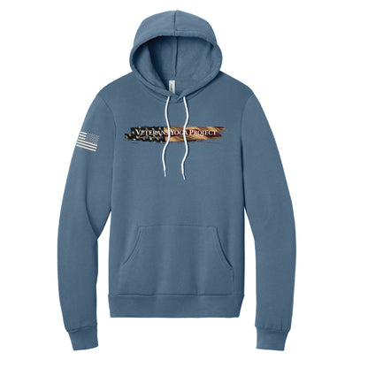 An indigo blue hoodie with the Veterans Yoga Project logo across the chest, backed by a vintage American flag graphic.  A charging American flag graphic is printed on the right sleeve.